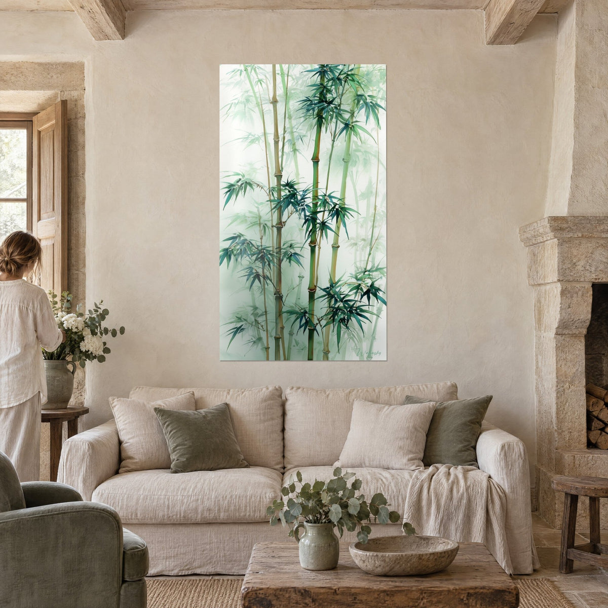 Tableau bambous en aquarelle verte et blanche dans la brume, femme de dos, cheminée en pierre, au-dessus d'un canapé dans un salon lumineux