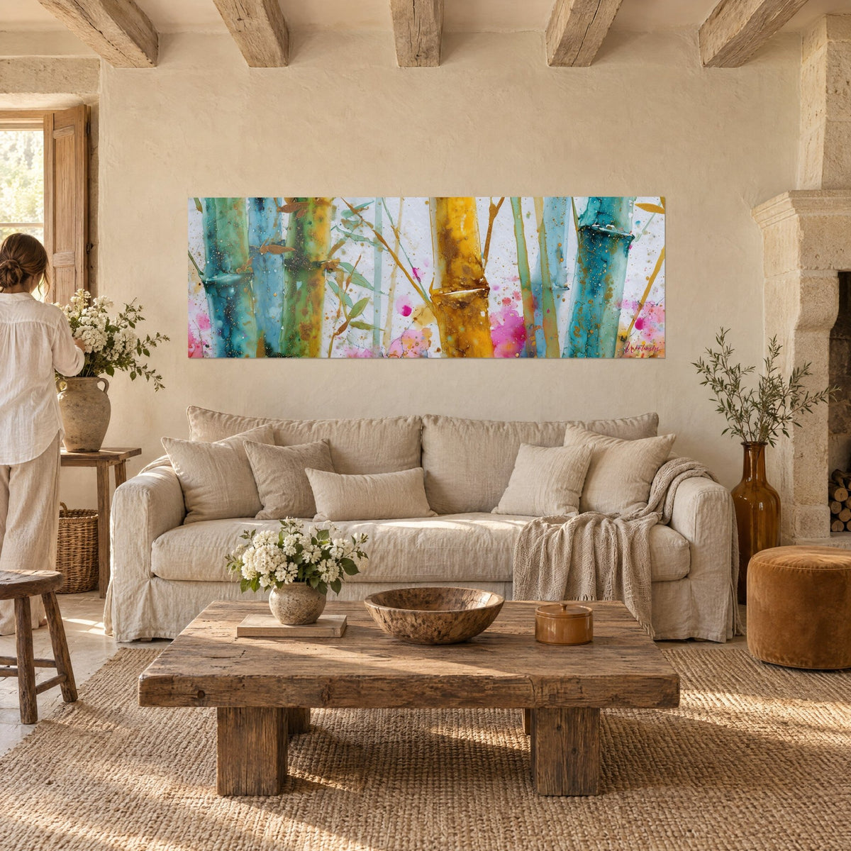 Tableau bambous aquarelle bleu sarcelle et jaune doré, éclaboussures roses, au-dessus d'un canapé dans un salon lumineux