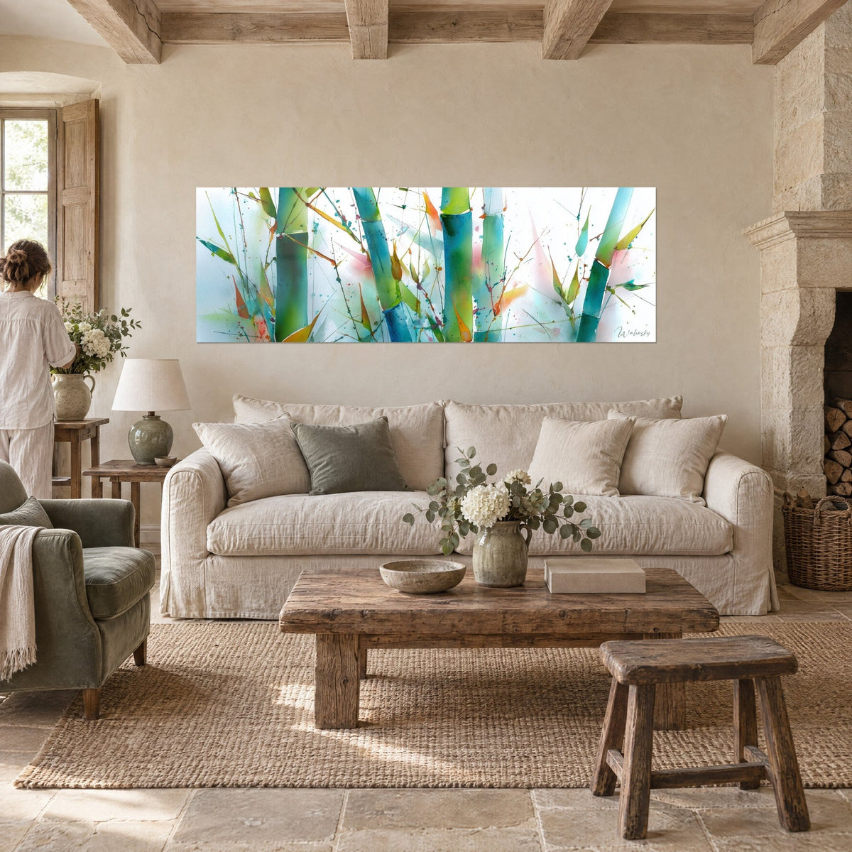Tableau tiges de bambou turquoise et vertes éclaboussées d'aquarelle, femme de dos, au-dessus d'un canapé dans un salon lumineux