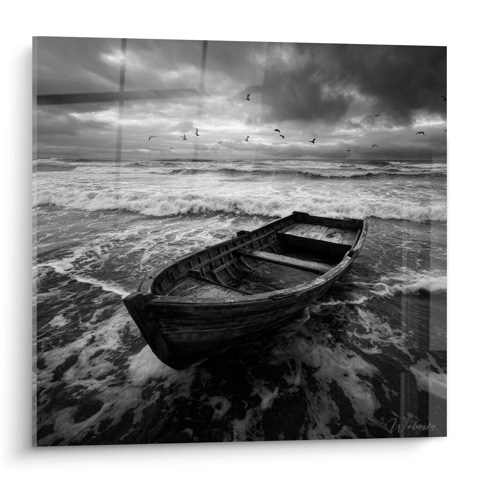 Tableau noir et blanc barque échouée sur plage avec ciel orageux et vagues déferlantes