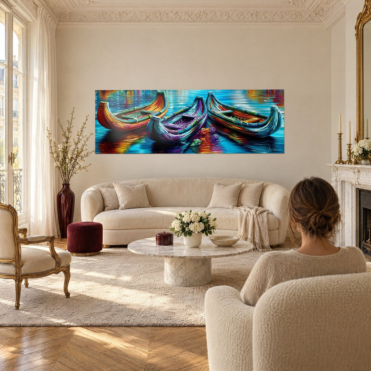 Cuadro de tres barcas coloridas en naranja, morado y turquesa sobre agua reluciente, encima de un sofá en un salón luminoso