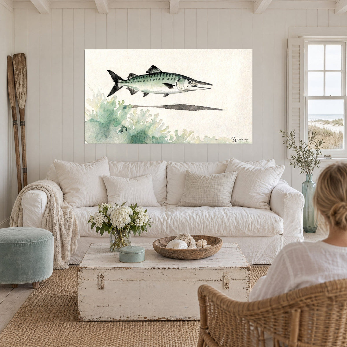Wall art barracuda in green and black gliding above turquoise coral, cream background, above a sofa in a bright living room
