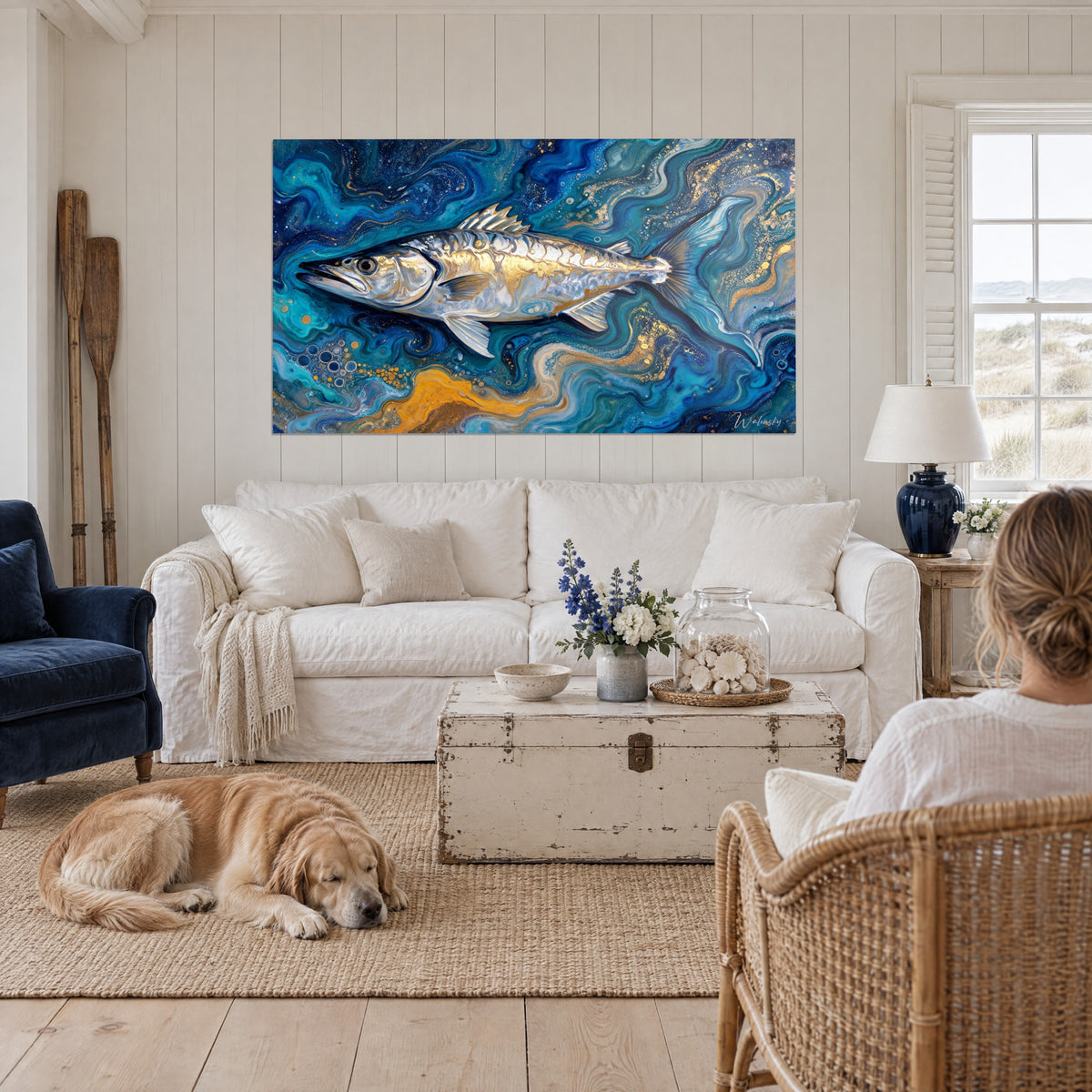 Wall art silver barracuda swimming through deep navy and gold swirls, above a sofa in a bright living room