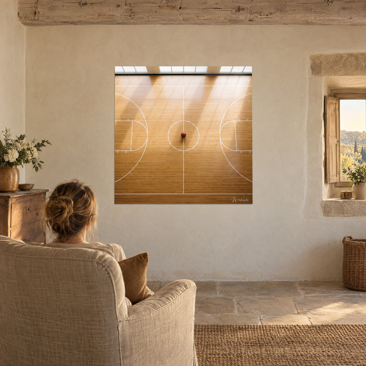 Wall art silent basketball arena, shadows of the glass walls on golden parquet and ivory lines, a woman seen from behind seated in a linen armchair
