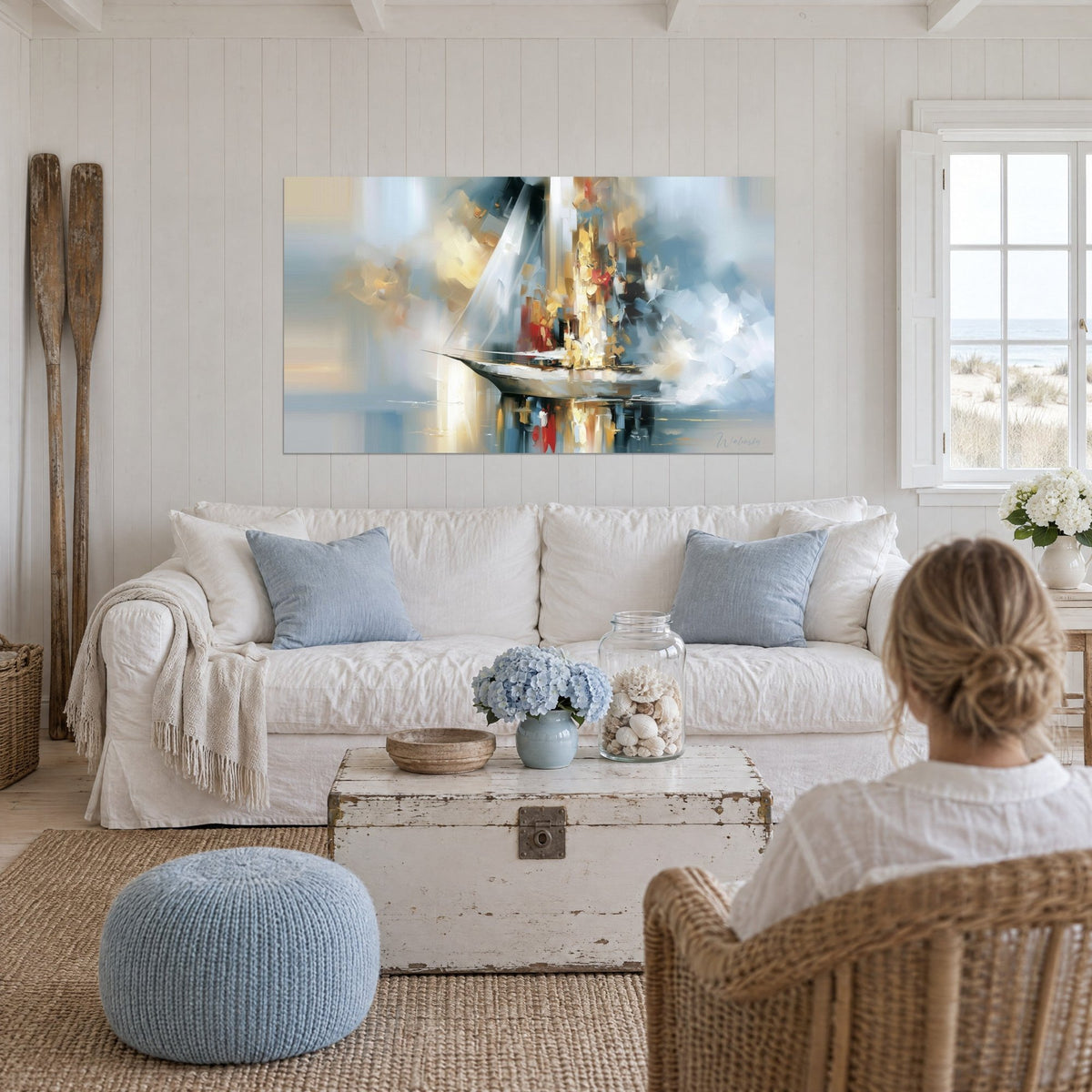 Tableau voilier blanc aux touches dorées et rouges, coque effilée, reflet sur l'eau, au-dessus d'un canapé dans un salon lumineux