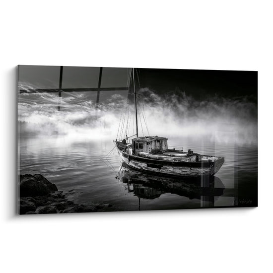 Vieux bateau en bois anthracite et blanc échoué sur une eau immobile enveloppée de brume