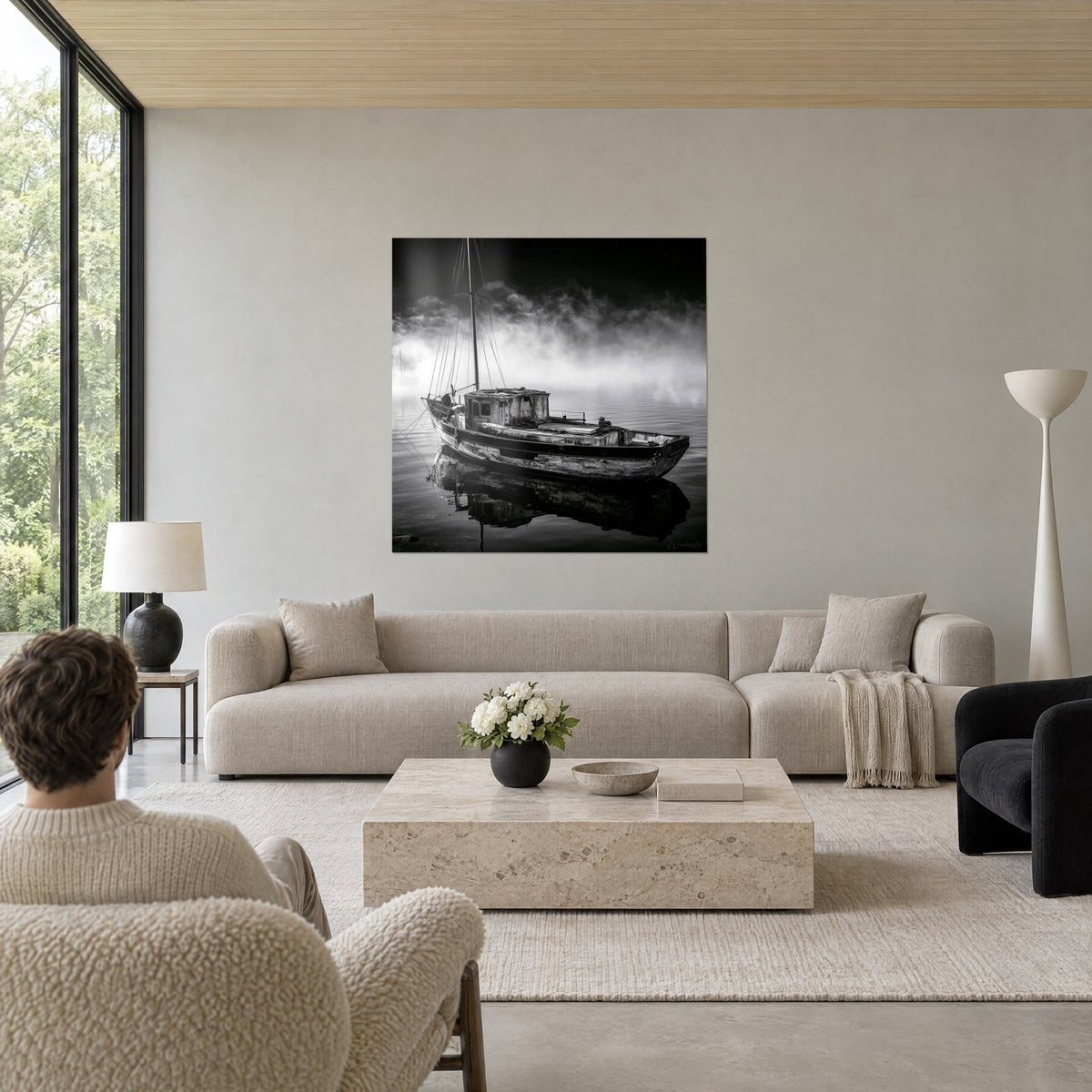 Tableau vieux chalutier en noir et blanc dans la brume, reflet sombre sur l'eau, deux personnes de dos, au-dessus d'un canapé dans un salon lumineux