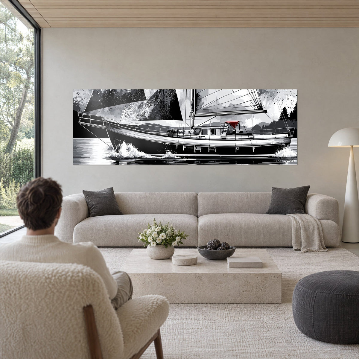 Schilderij zwart-wit zeilboot die door het water snijdt, grafische zeilen en rode kajuit, van achteren gezien door een man boven een bank in een lichte woonkamer