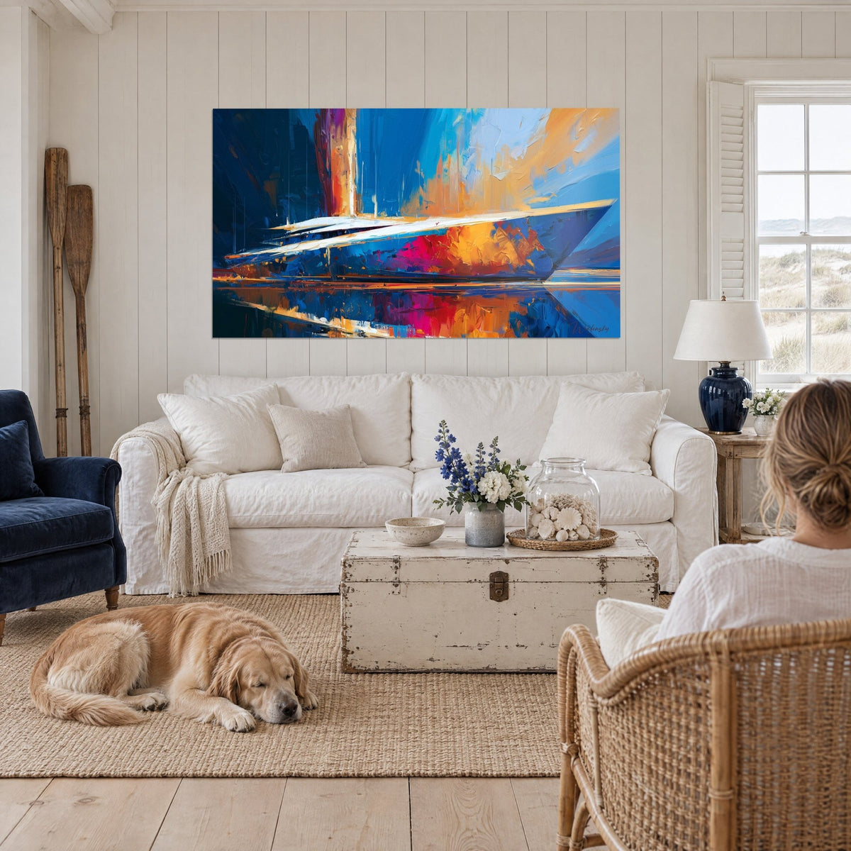 Tableau yacht fendant un reflet fuchsia, bleu cobalt et ocre à la spatule, au-dessus d'un canapé dans un salon lumineux