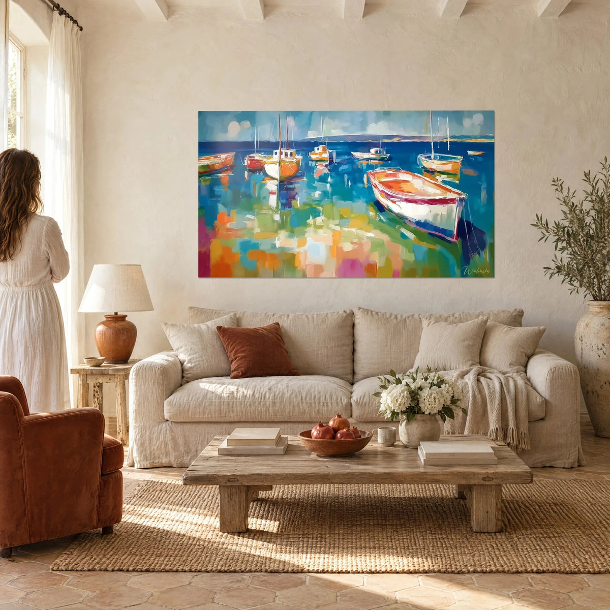 Wall art of white and red boats floating on cobalt blue water, thick brushstrokes, woman seen from behind, above a sofa in a bright living room