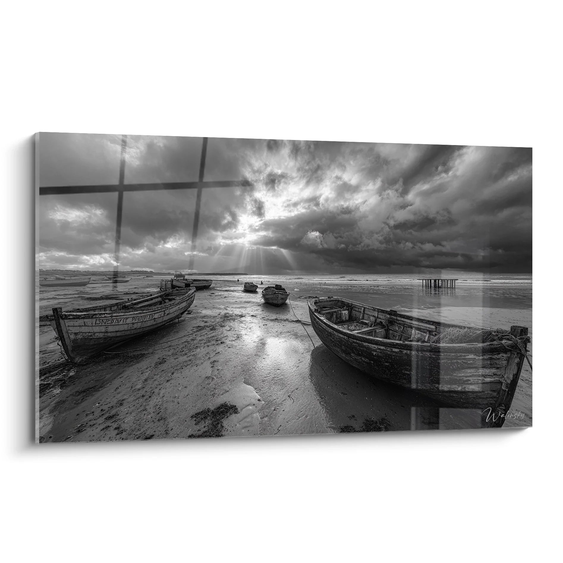 Tableau noir et blanc de bateaux de pêche échoués sur plage avec ciel dramatique et reflets sur sable
