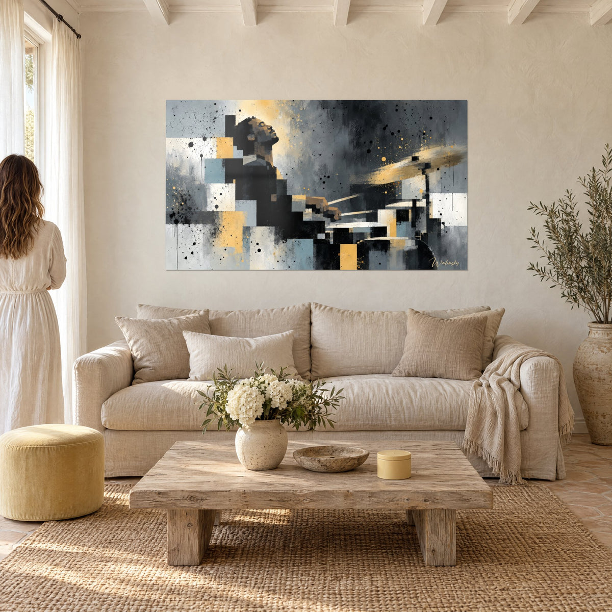 Tableau batteur renversant la tête, blocs gris et dorés, taches d'encre noire, au-dessus d'un canapé dans un salon lumineux