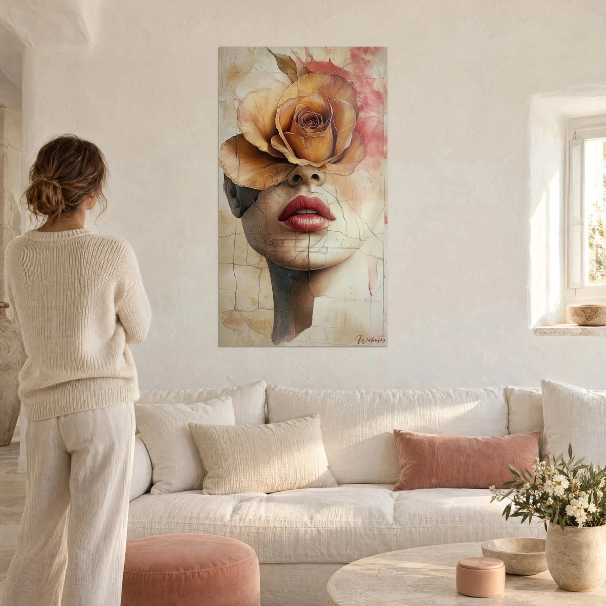 Wall art woman's face hidden behind an ochre rose, red lips, beige cracked background, above a sofa in a bright living room