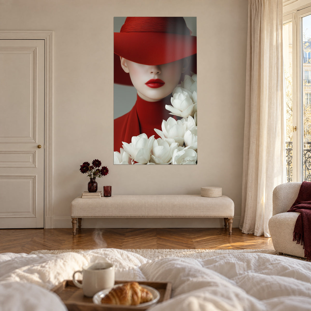 Quadro volto in parte nascosto da una tesa di cappello rosso vivo, bouquet di fiori crema, sopra un letto in una camera chiara