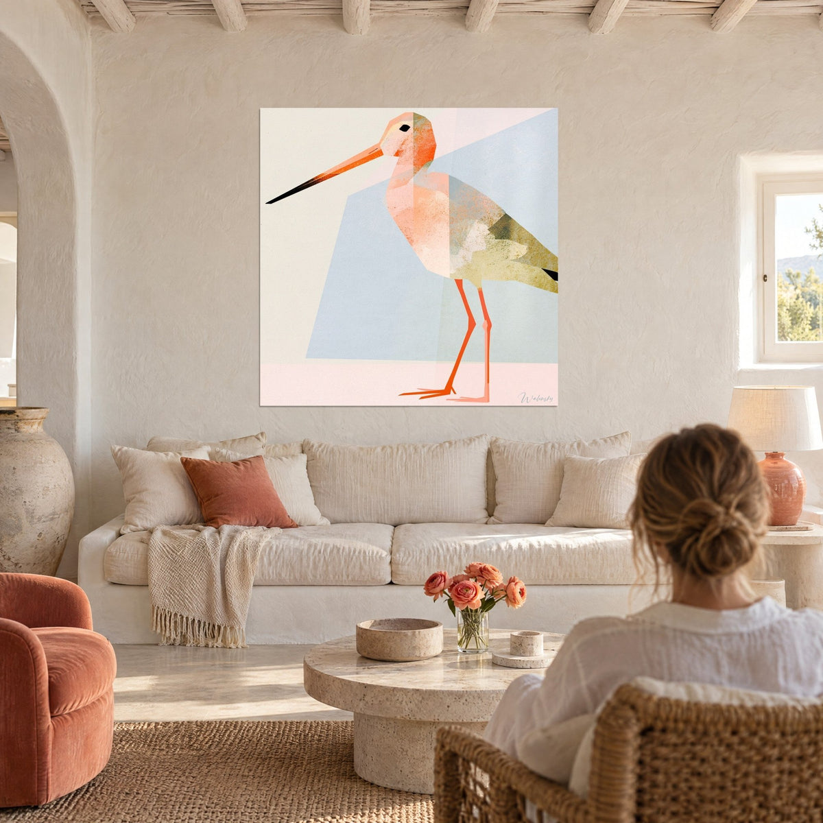 Tableau bécasse géométrique au long bec orange, plumage rose pâle et olive sur fond bleu ciel, au-dessus d'un canapé dans un salon lumineux