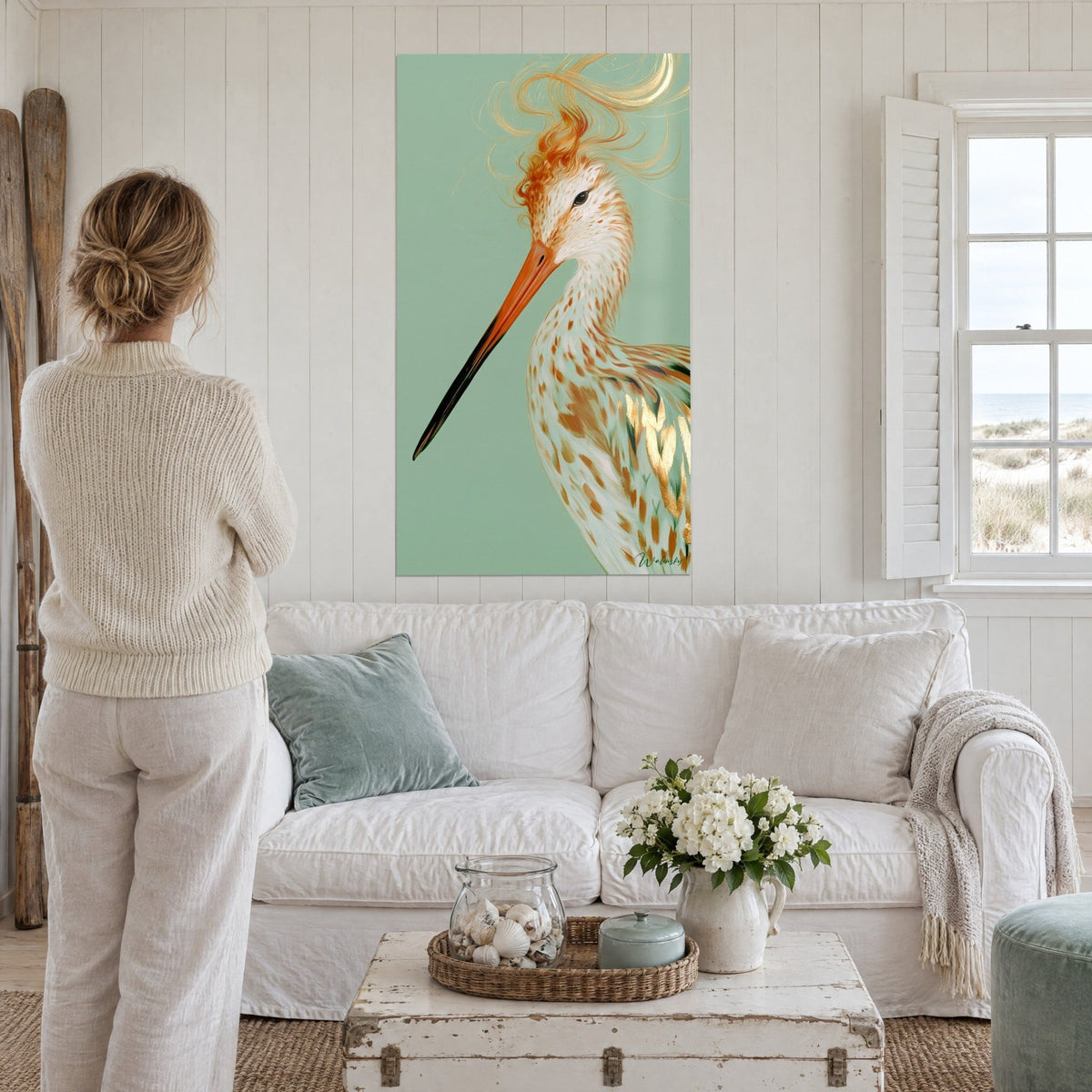 Schilderij houtsnip met lange oranje snavel en gouden verenkleed op saliegroene achtergrond, boven een bank in een lichte woonkamer