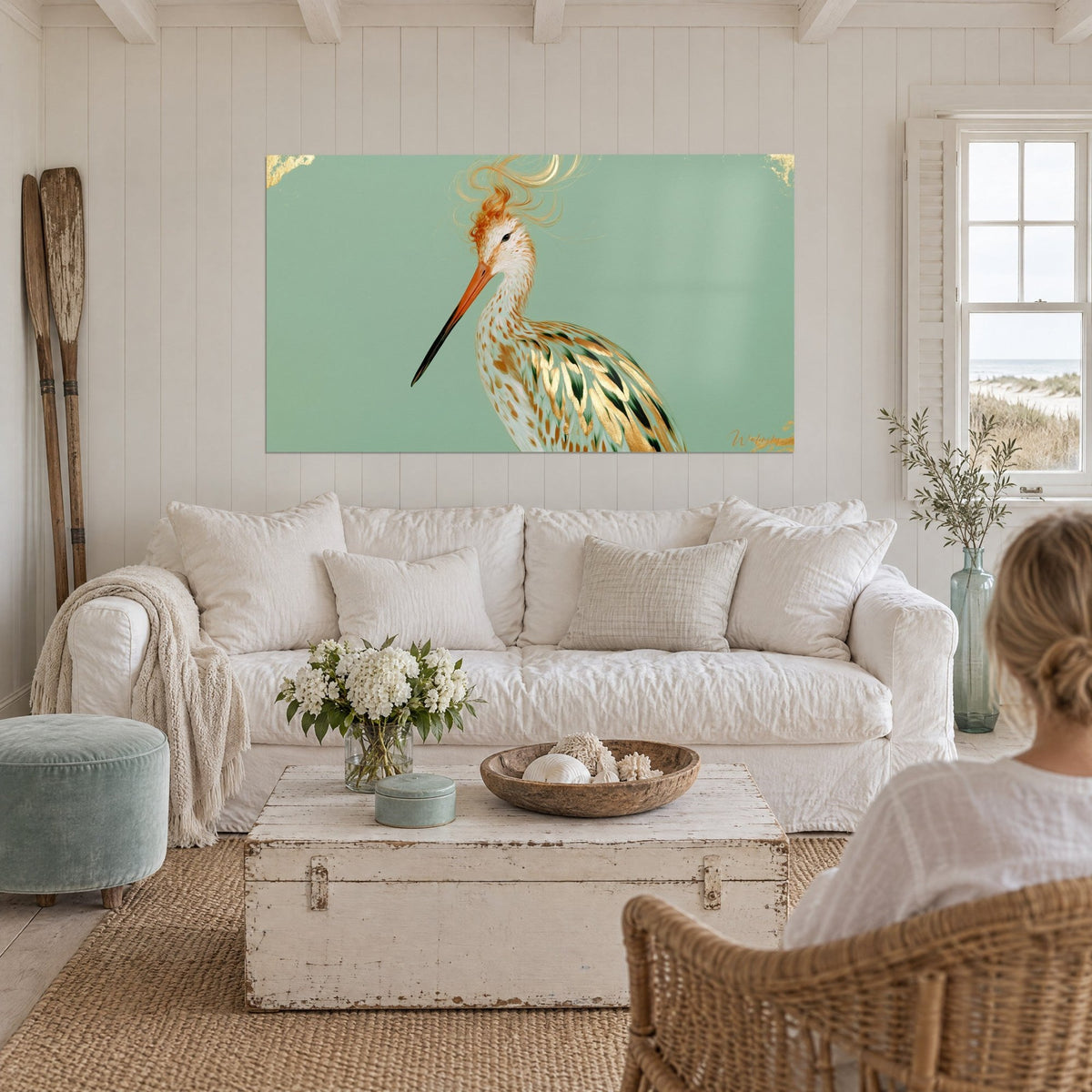 Tableau bécasse à huppe orange en tourbillon sur fond vert sauge, plumes dorées, au-dessus d'un canapé dans un salon lumineux