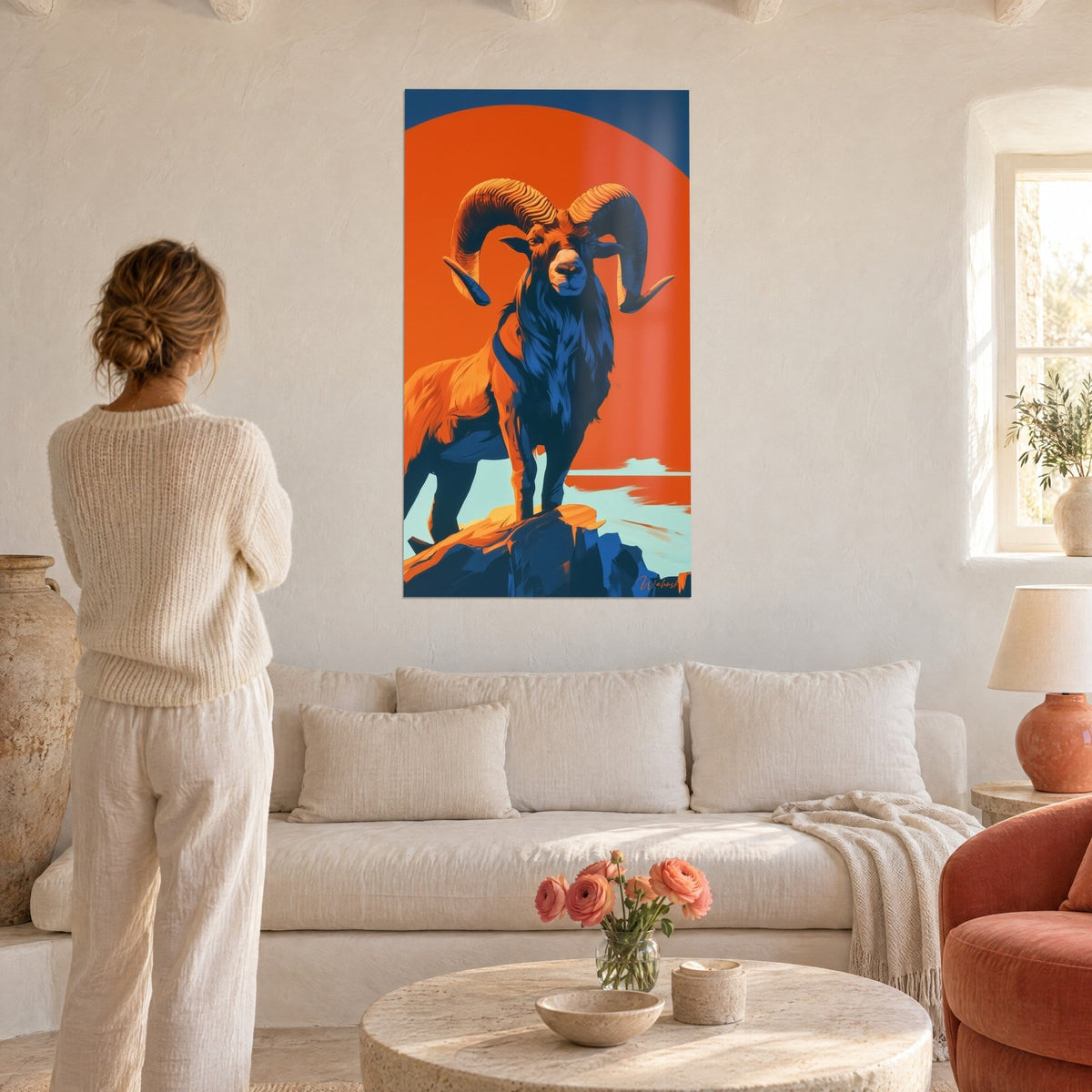 Tableau bélier aux cornes spiralées sur disque orange, pelage bleu marine, au-dessus d'un canapé dans un salon lumineux