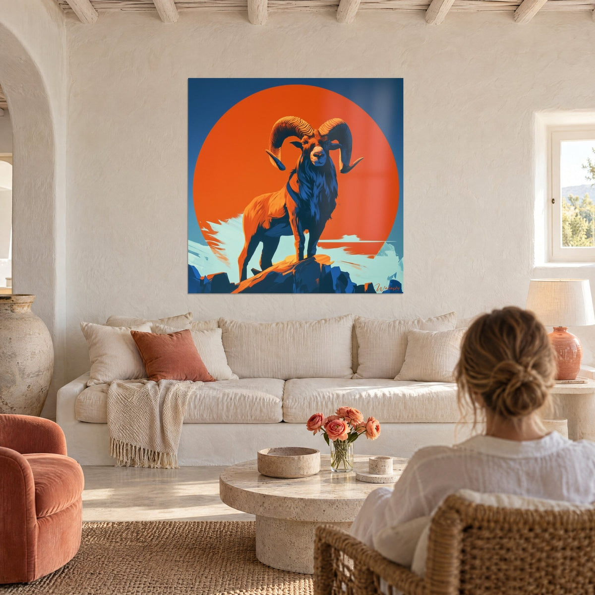 Schilderij van een majestueuze ram met spiraalvormige hoorns voor een oranje zonneschijf, nachtblauwe hemel, boven een bank in een lichte woonkamer