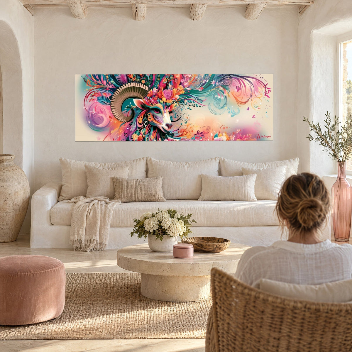 Tableau bélier fleuri aux cornes spiralées, plumes sarcelle et fleurs corail, au-dessus d'un canapé dans un salon lumineux