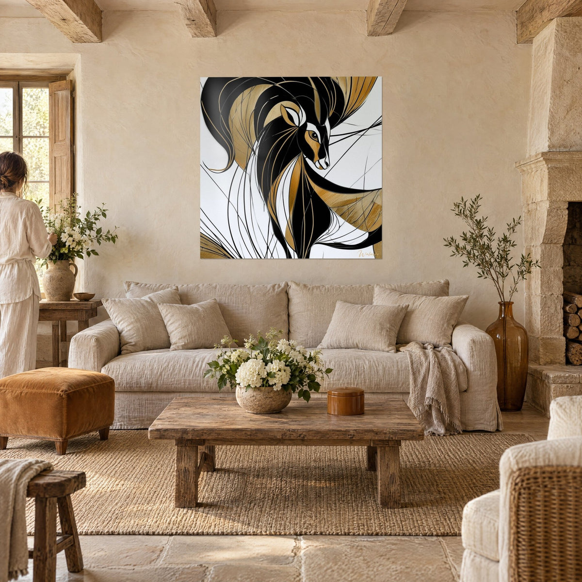 Tableau bélier stylisé aux cornes noires en volutes et reflets dorés, face à une femme de dos, au-dessus d'un canapé dans un salon lumineux