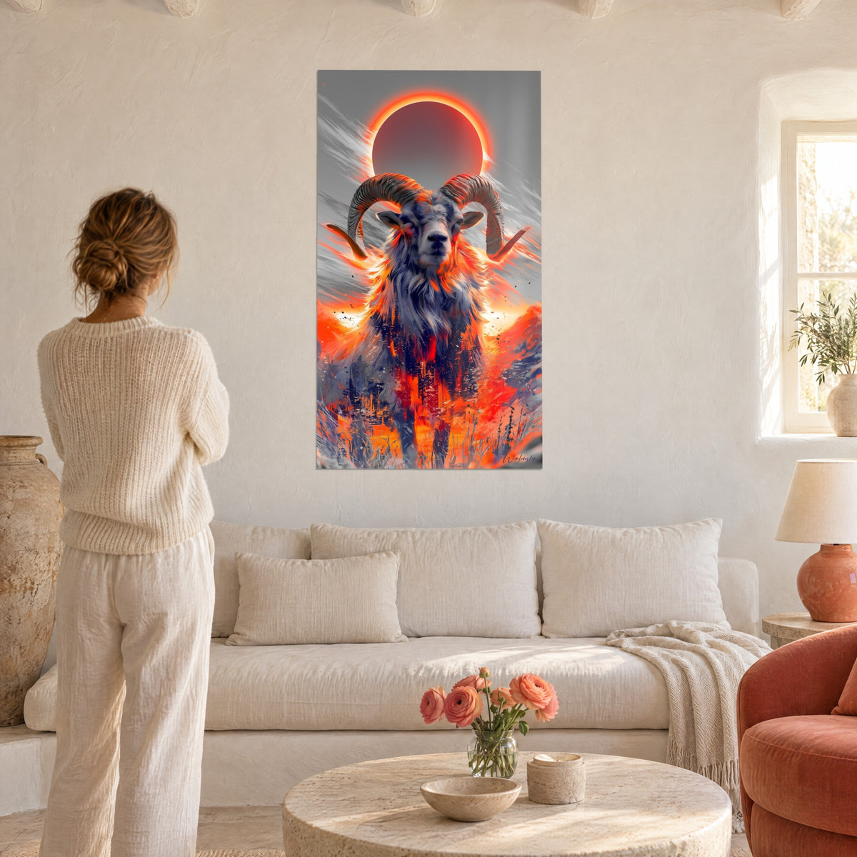 Tableau bélier aux cornes spiralées anthracite sous un disque d'éclipse rouge et orange, au-dessus d'un canapé dans un salon lumineux
