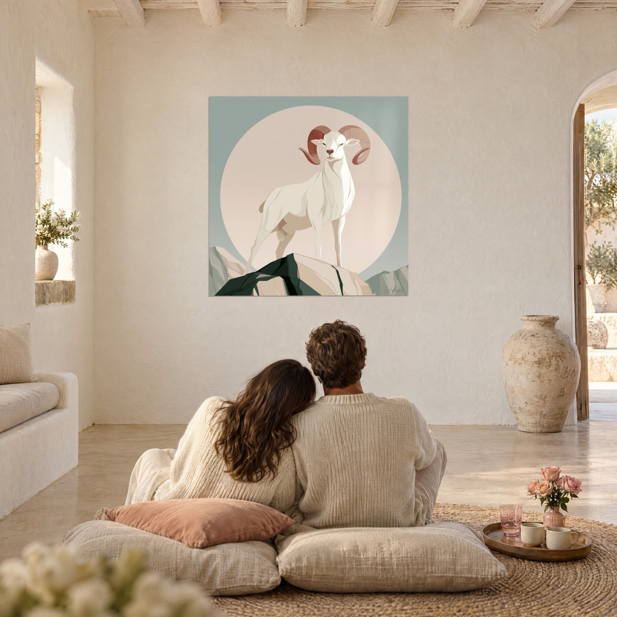 Quadro montone di profilo fiero, corna terracotta arrotolate su un alone ocra rosato, coppia abbracciata su cuscini in un soggiorno imbiancato