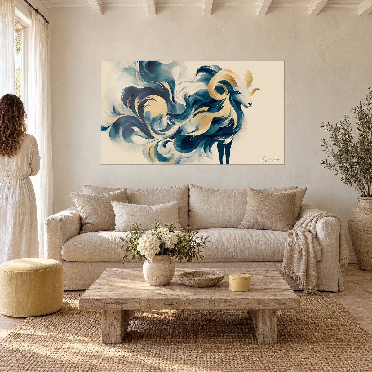 Quadro ariete con corna dorate arrotolate, volute blu navy su fondo crema, sopra un divano in un soggiorno luminoso