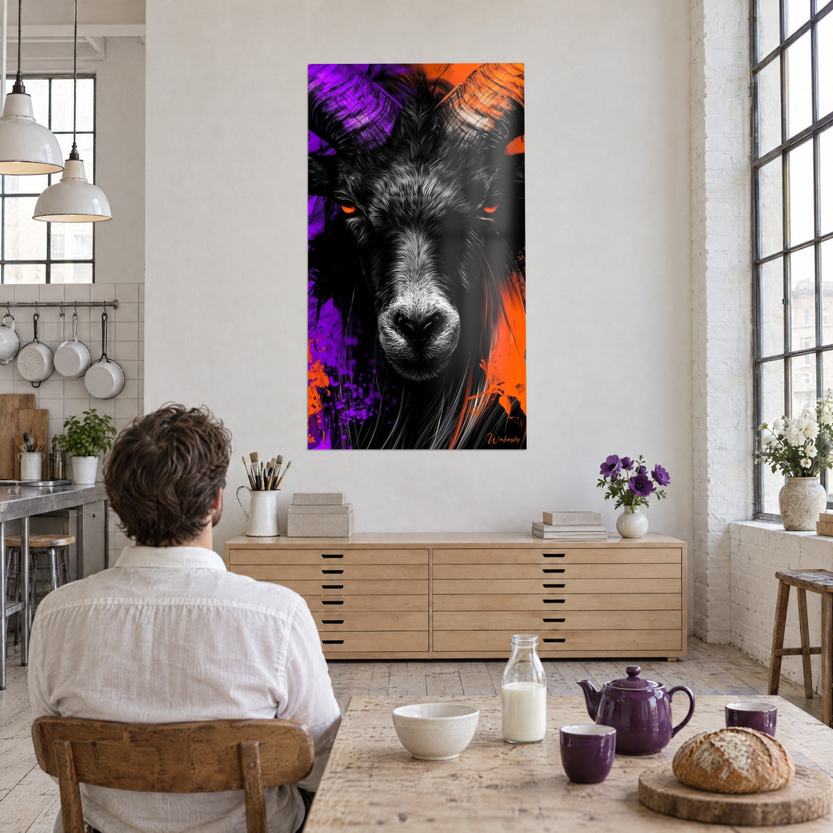 Quadro testa di ariete color carbone, corna viola e arancio, due occhi ardenti, cucina loft, uomo seduto al tavolo