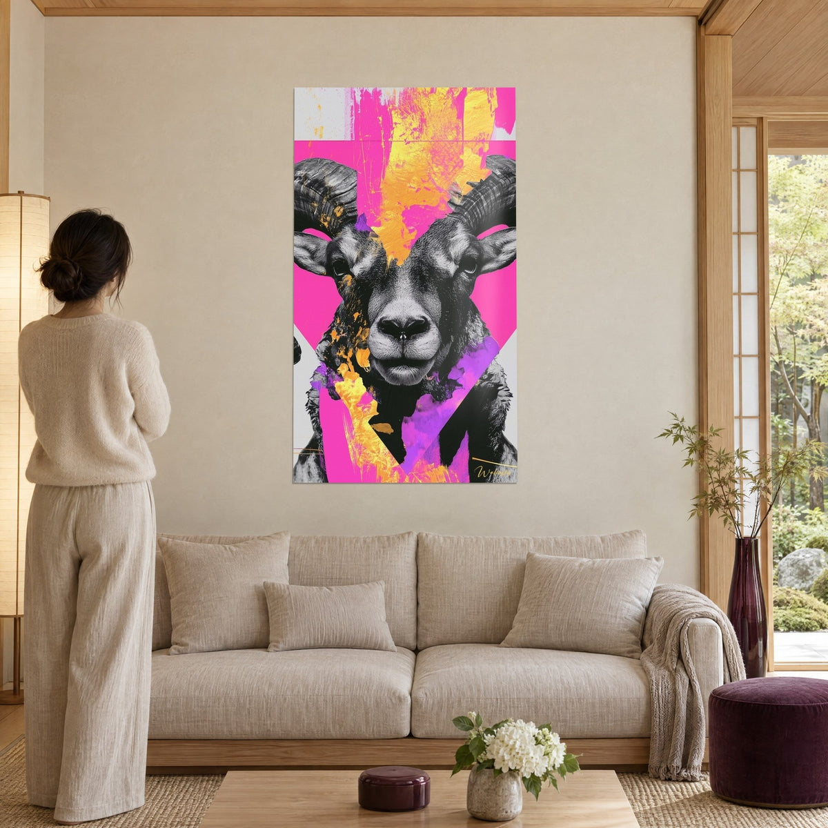 Cuadro carnero de cuernos espiralados en blanco y negro sobre fondo fucsia y amarillo azafrán, encima de un sofá en un salón luminoso