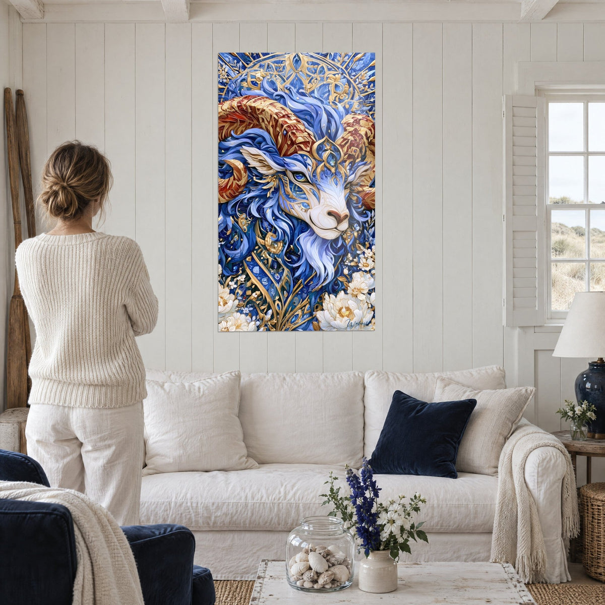 Quadro ariete con corna rosse e oro, vello blu ondulato, fiori bianchi, sopra un divano in un soggiorno luminoso