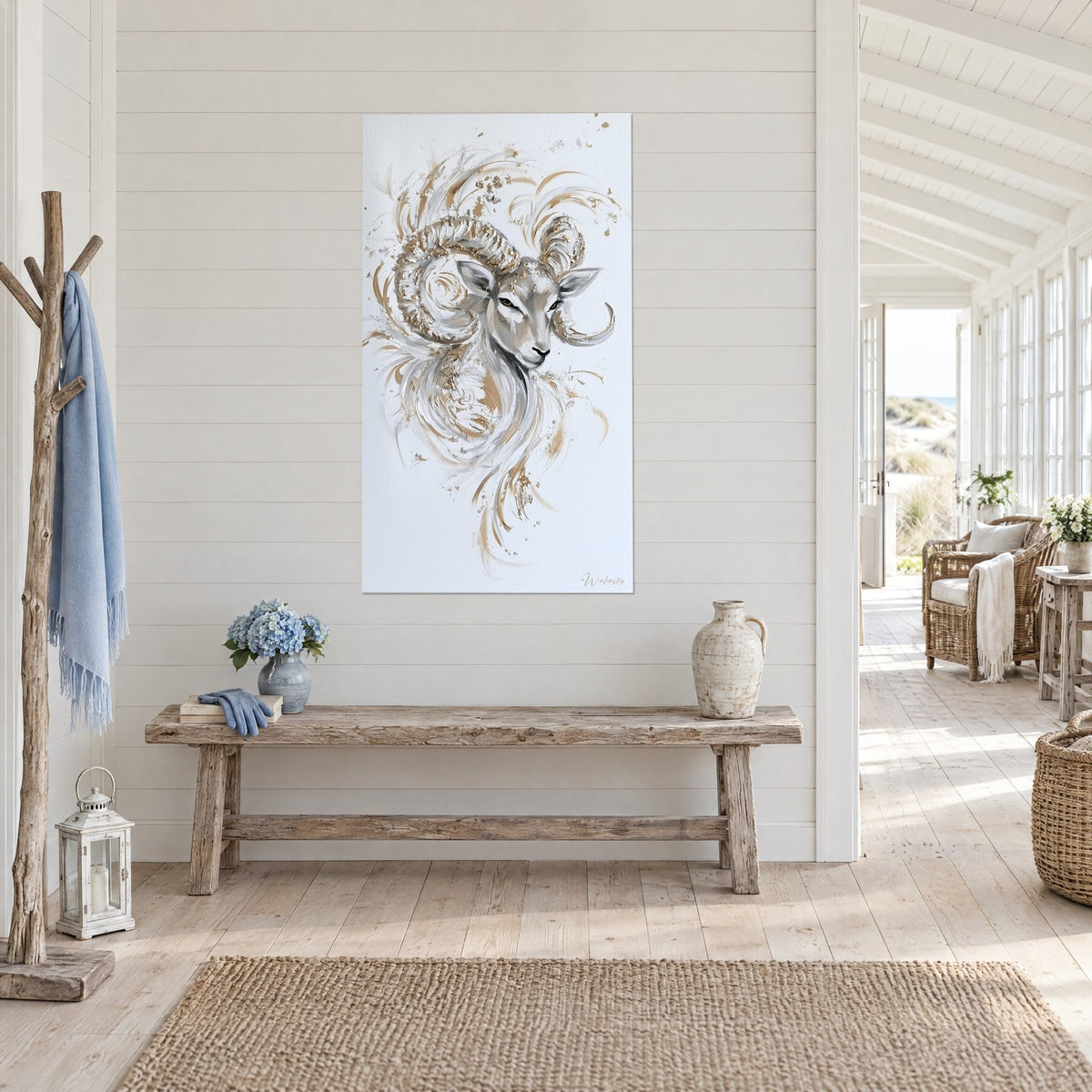 Quadro testa di pecora con volute grigie e oro schizzate su fondo bianco, panca in legno, in una casa al mare