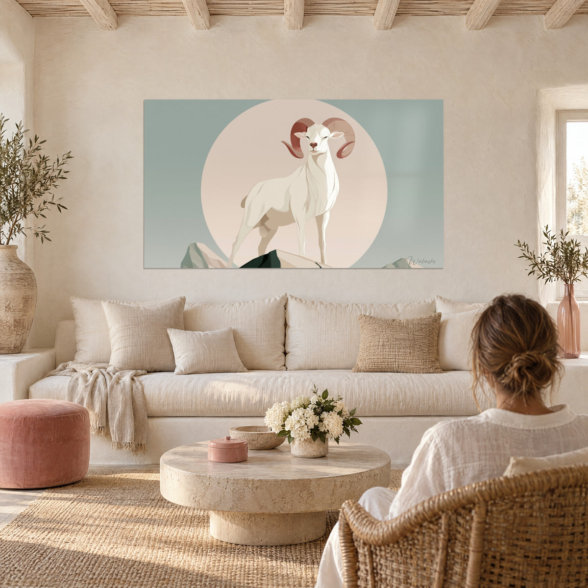 Gemälde Widder elfenbein mit rosafarbenen Hörnern vor einem großen puderfarbenen Kreis, graugrüner Hintergrund, über einem Sofa in einem hellen Wohnzimmer
