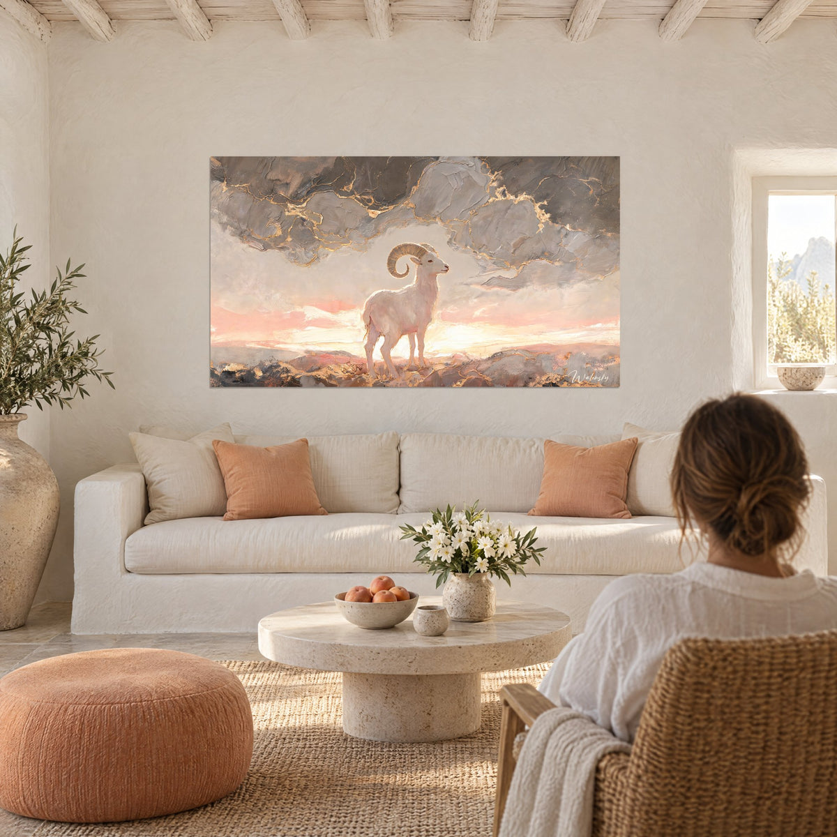 Tableau mouflon blanc aux cornes spiralées dorées sur ciel rose et gris veiné d'or, au-dessus d'un canapé dans un salon lumineux