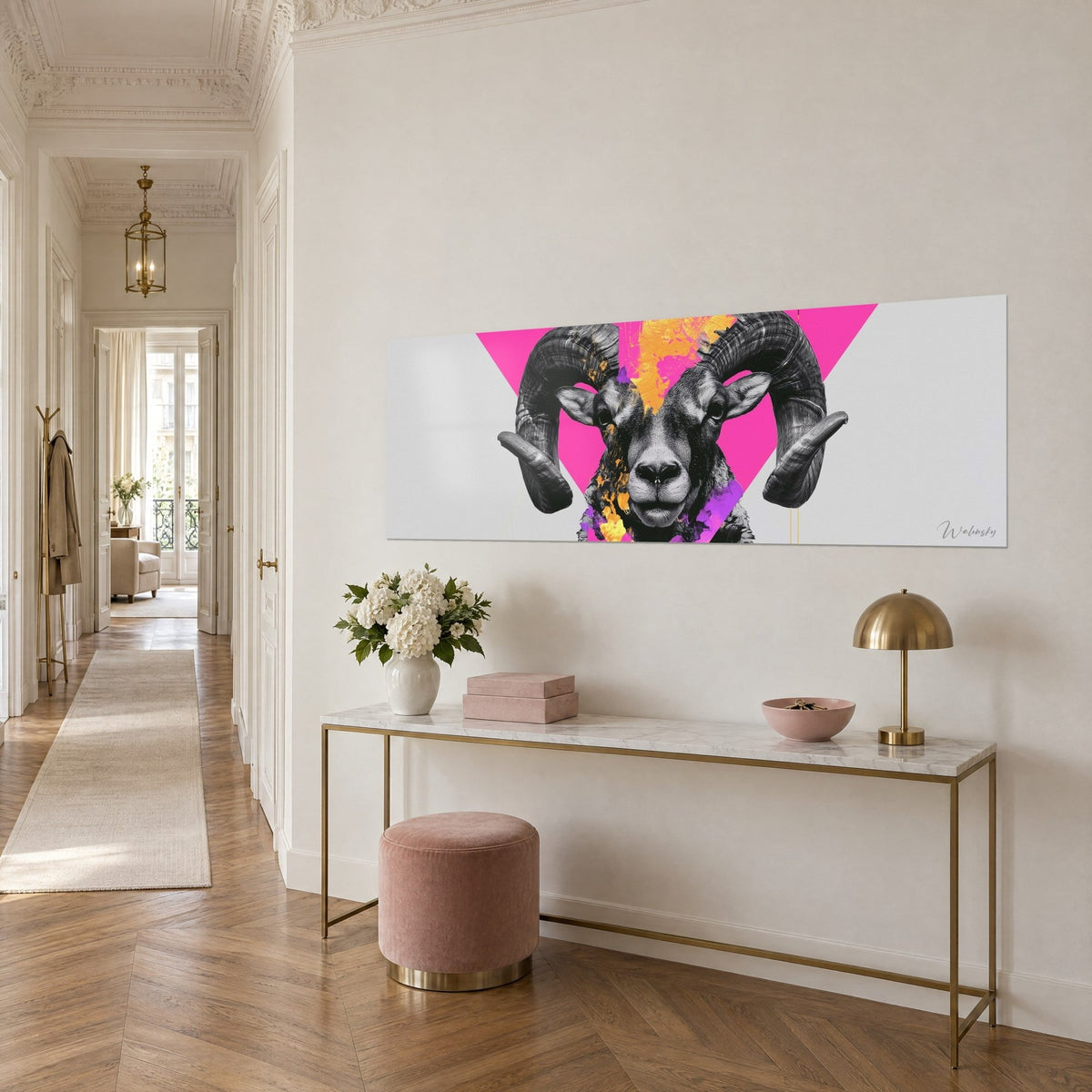 Quadro testa d'ariete in bianco e nero sotto un triangolo rosa vivace, tocchi arancio e viola, su una consolle dorata in vista di tre quarti