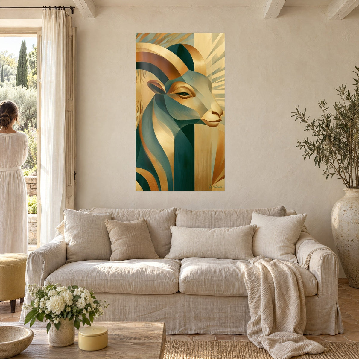 Schilderij met geometrische ram, gedraaide gouden hoorns in smaragdgroen, gezien door een vrouw van achteren boven een bank in een lichte woonkamer