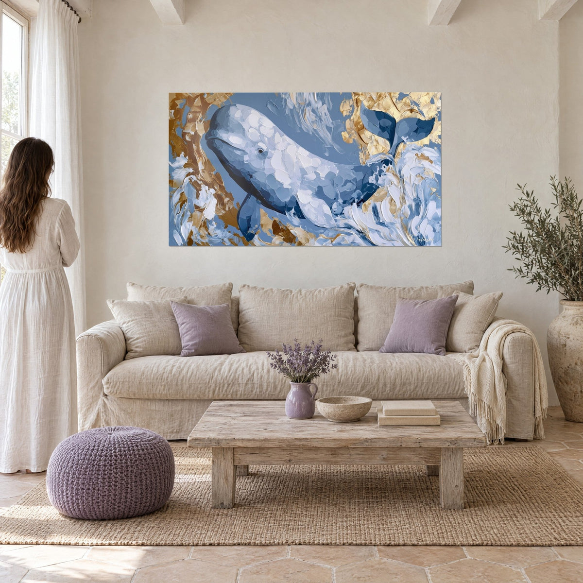 Tableau béluga blanc nacré nageant en diagonale, fond bleu ardoise et éclats dorés, au-dessus d'un canapé dans un salon lumineux