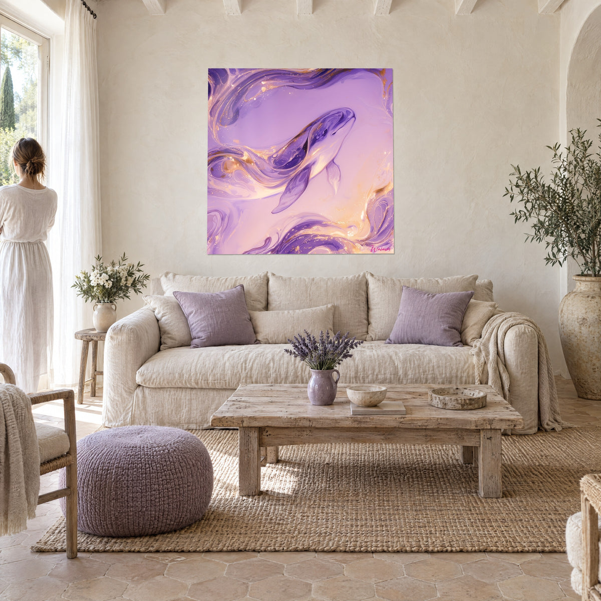 Tableau baleine blanche glissant dans des volutes lilas et or, femme de dos, au-dessus d'un canapé dans un salon lumineux