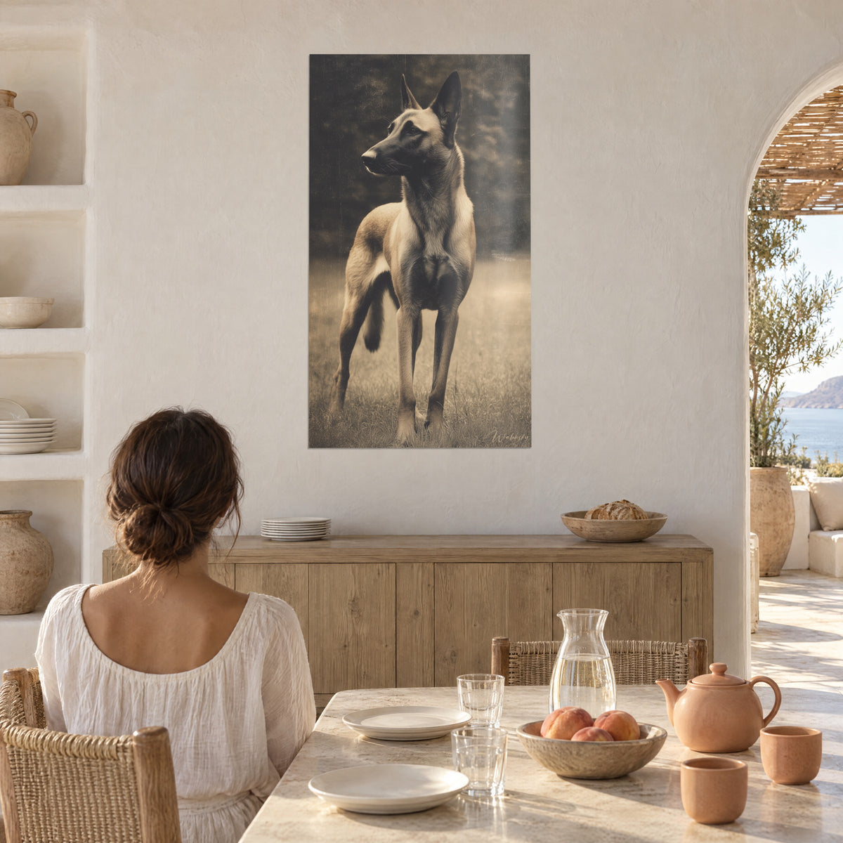 Πίνακας Δυναμικό πορτρέτο Malinois με λεπτά πόδια, μπεζ και μαύρο τρίχωμα, σε ασβεστωμένο τοίχο δίπλα σε ανοιχτή καμάρα με θέα στη θάλασσα