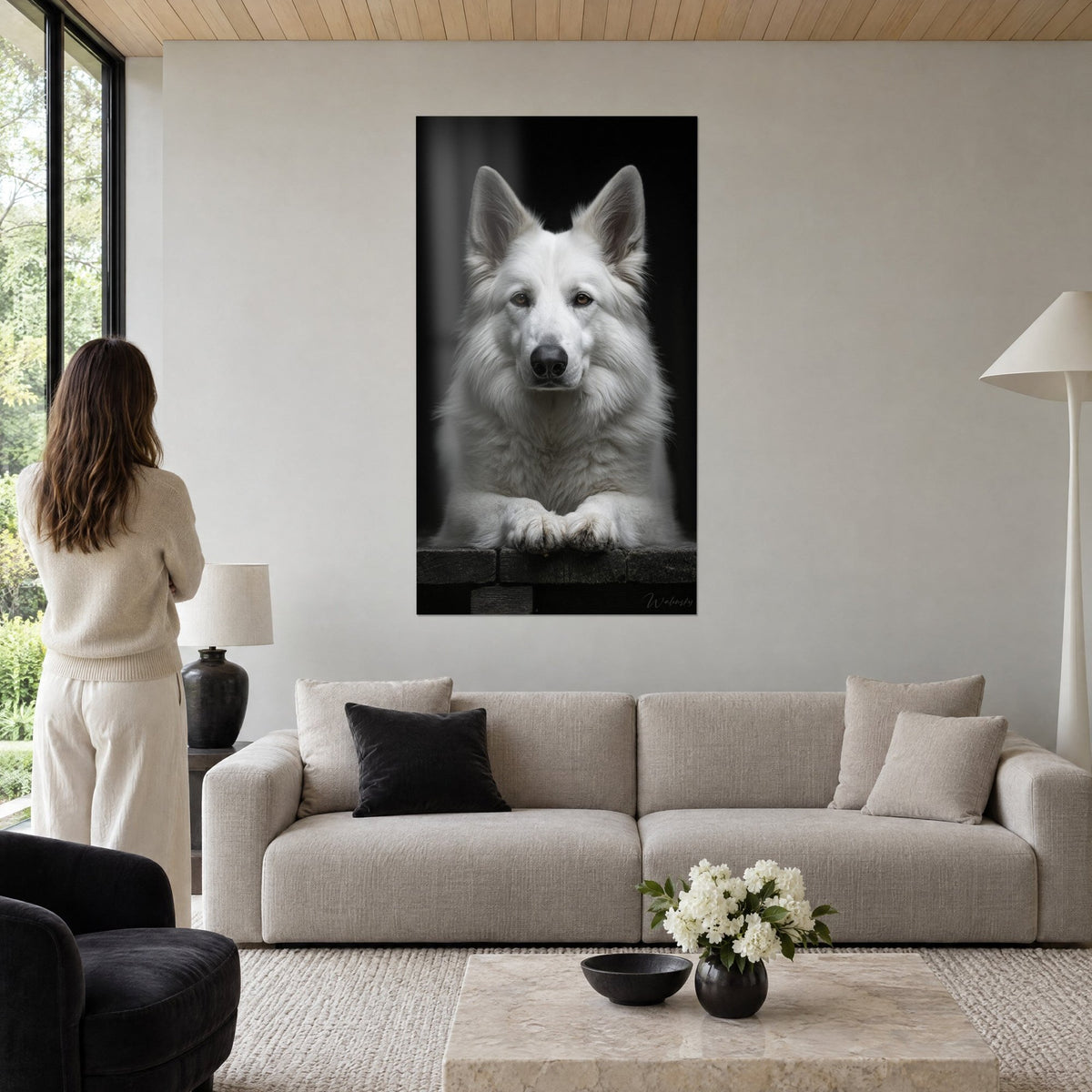Wall art majestic white dog with amber eyes, crossed paws on a deep black background, above a sofa in a bright living room
