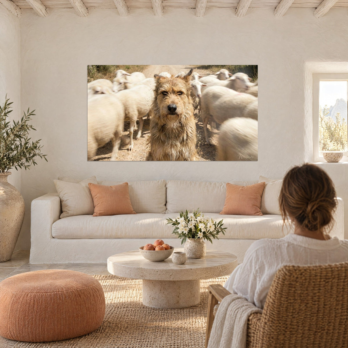 Gemälde Greifhund mit fahlem Fell und dunklem Blick vor cremefarbenen Schafen, über einem Sofa in einem hellen Wohnzimmer