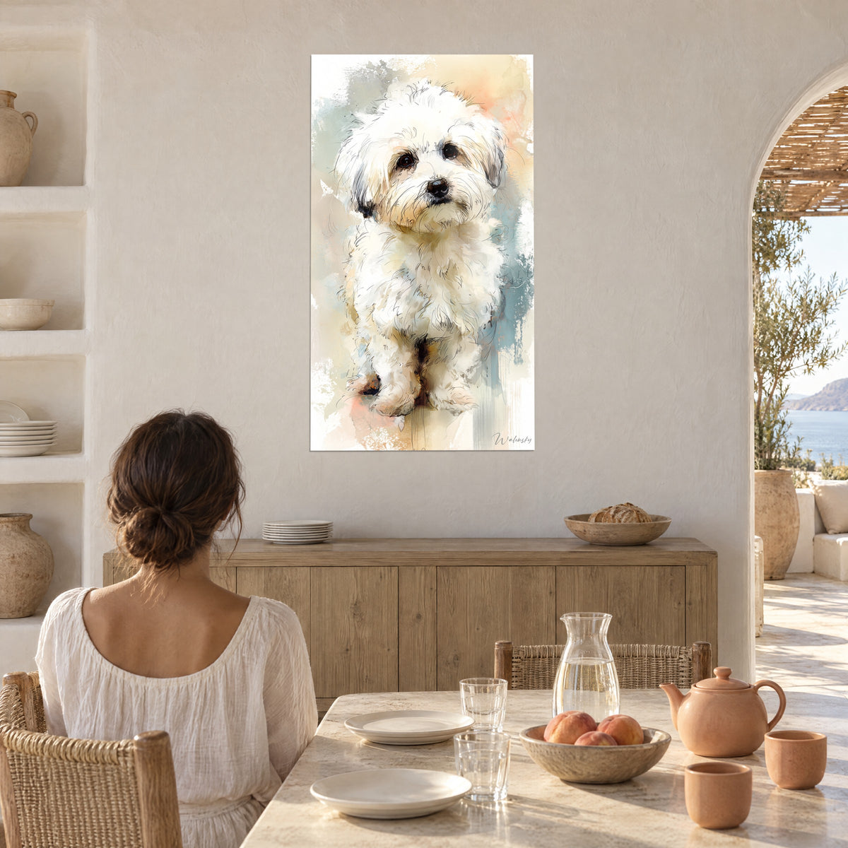 Cuadro de perrito de pelo largo blanco y hocico negro, aguada albaricoque y azul celadón, pared encalada de un comedor junto a un arco abierto al mar