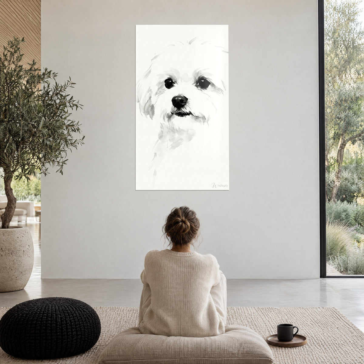 Wall art portrait of a Maltese in diluted ink, black gaze and white coat, woman seated from behind on a pouf in a minimalist living room