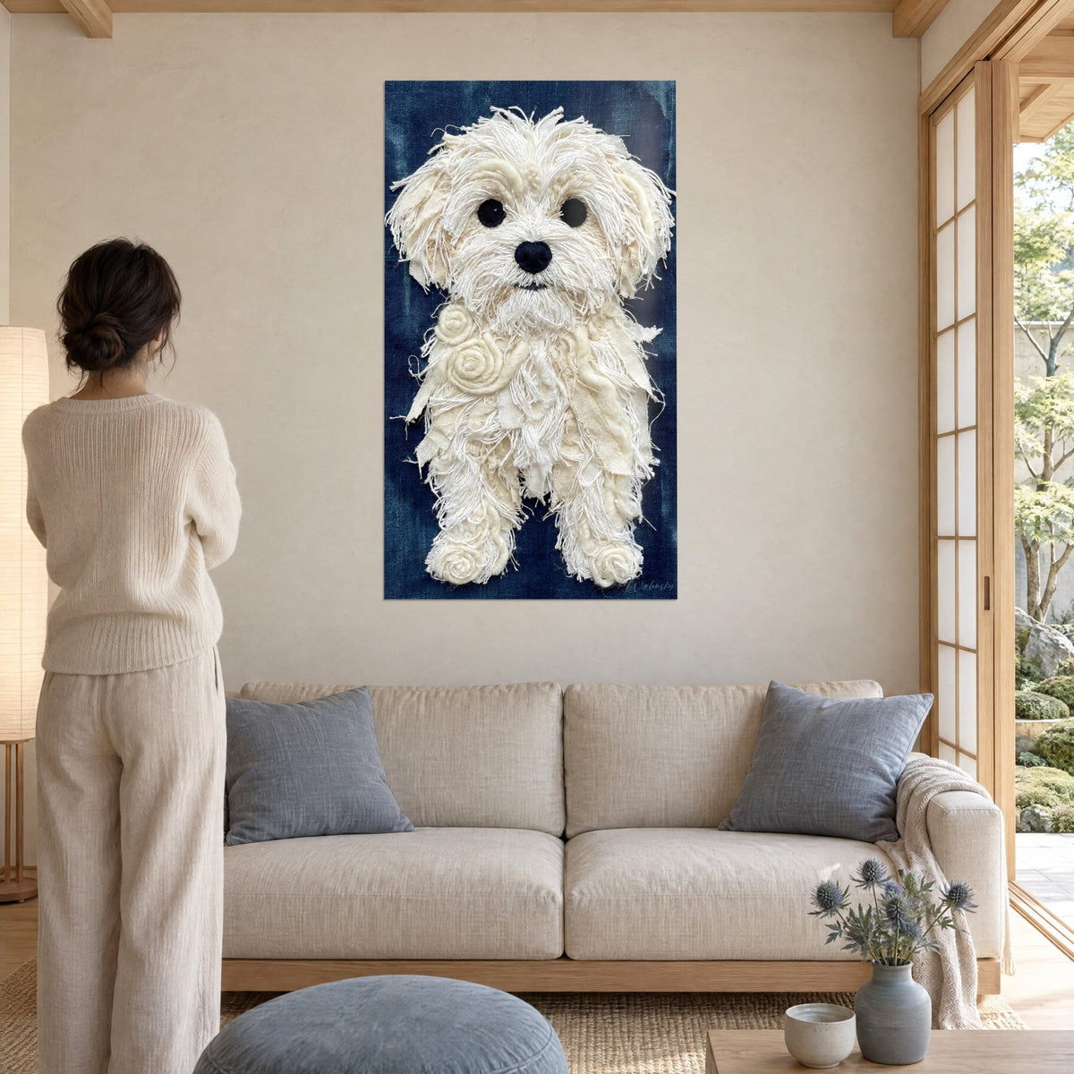 Wall art Maltese bichon in cream fibres on navy blue background, dark gaze, hung above a sofa in a bright living room
