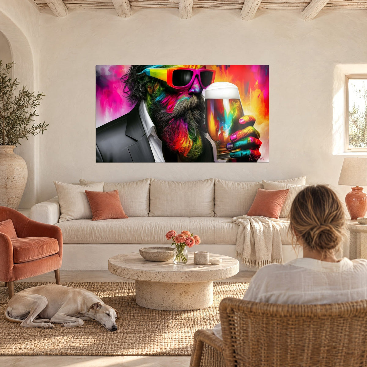 Wall art of a bearded man in pink glasses raising his frothy beer mug, magenta and orange background, above a sofa in a bright living room