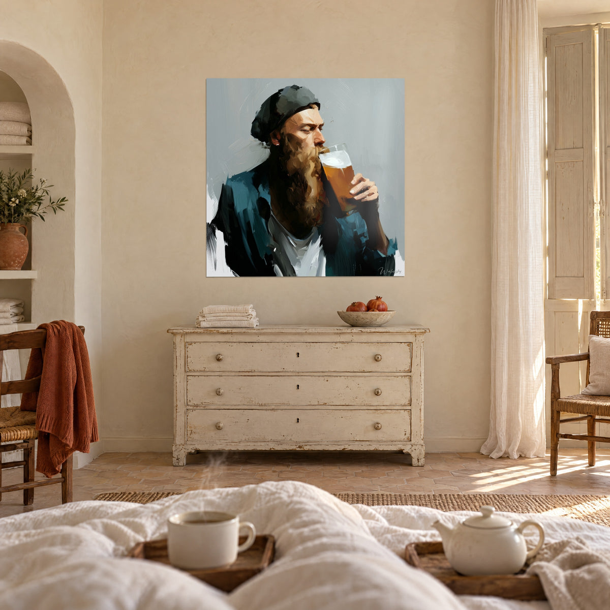 Wall art of a man in a dark beanie bringing a glass of amber beer to his lips, copper-toned beard, blue jacket, above a bed in a bright bedroom