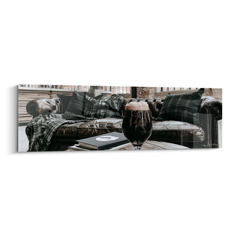Tableau Verre ballon brun foncé et noir près d'un canapé en cuir - Livre et coussin écossais - Edition Bière