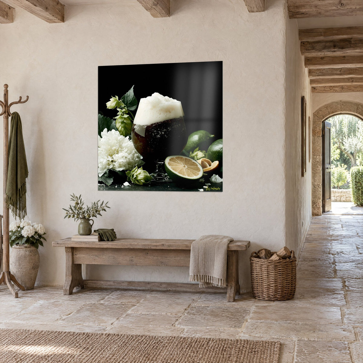 Tableau verre ambré à col de cygne, fleur blanche et citron vert coupé sur fond noir, accroché sur un mur de pierre, banc de bois, couloir