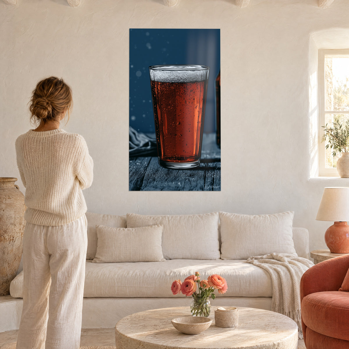 Cuadro jarra de cerveza ámbar con espuma blanca sobre fondo azul noche, mujer de espaldas, encima de un sofá en un salón luminoso