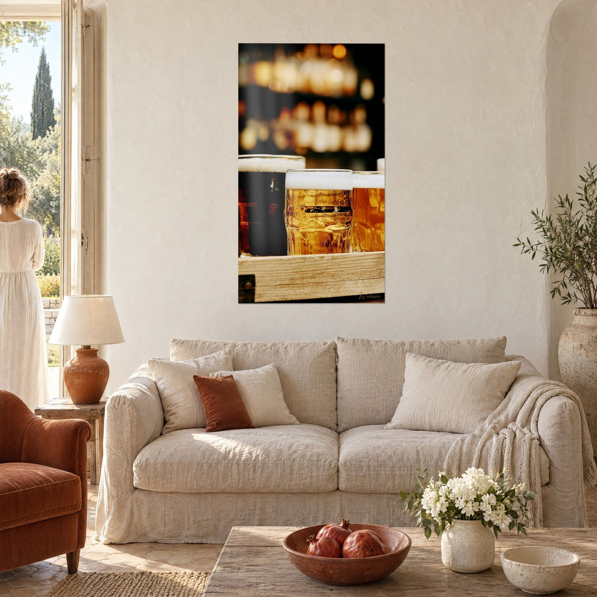 Tableau trois chopes de bière blonde et brune, mousse blanche épaisse et lumières ambrées floues, au-dessus d'un canapé dans un salon lumineux